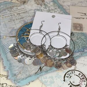 silver-toned hoop earrings with mother-of-pearl shell disc charms.